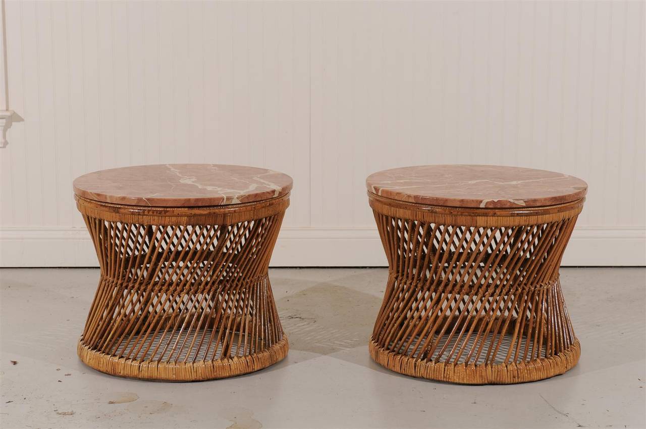 An exceptional pair of vintage tables, circa 1970s.  Stout steel frame construction wrapped in rattan with a lovely marble top. Beautifully made pieces.  May serve as end, drink or coffee tables.  Fabulous Jewelry !  These tables were a part of the