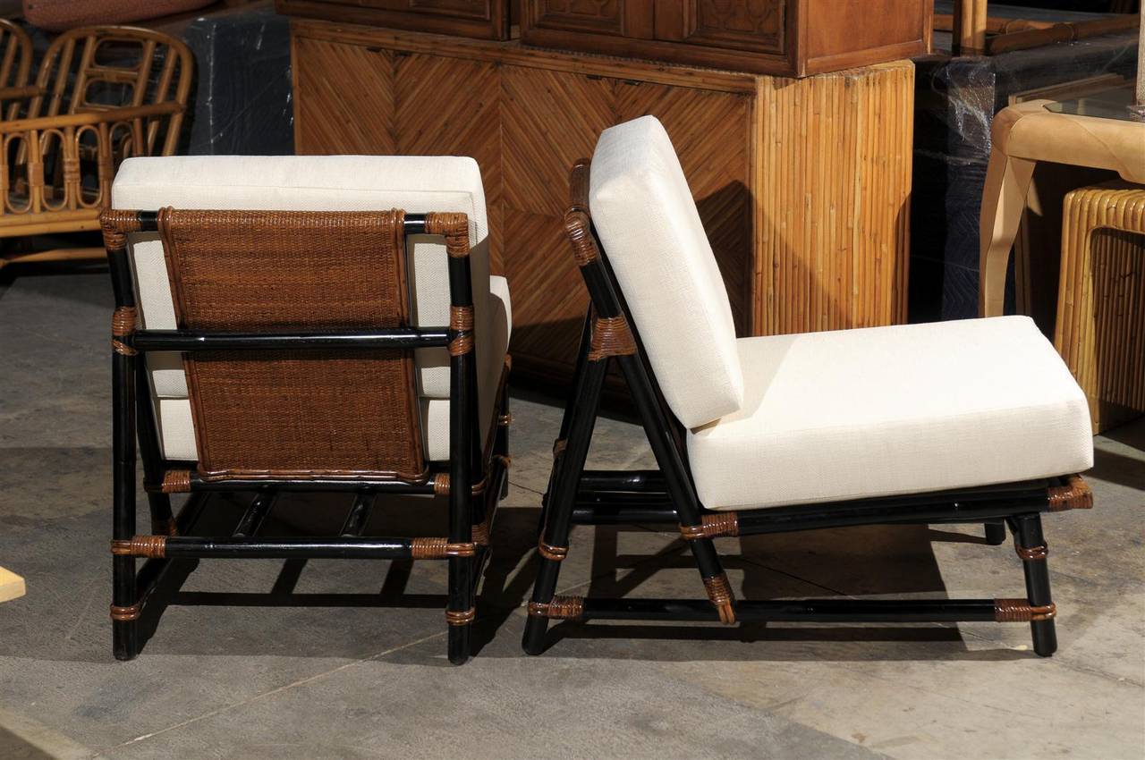 An exceptional pair of tailored slipper lounge chairs. Rattan frame with beautiful raffia seat back and bindings. Aged to absolute perfection. The pair are shipped completely installation ready.  These unusual chairs are examples from the 