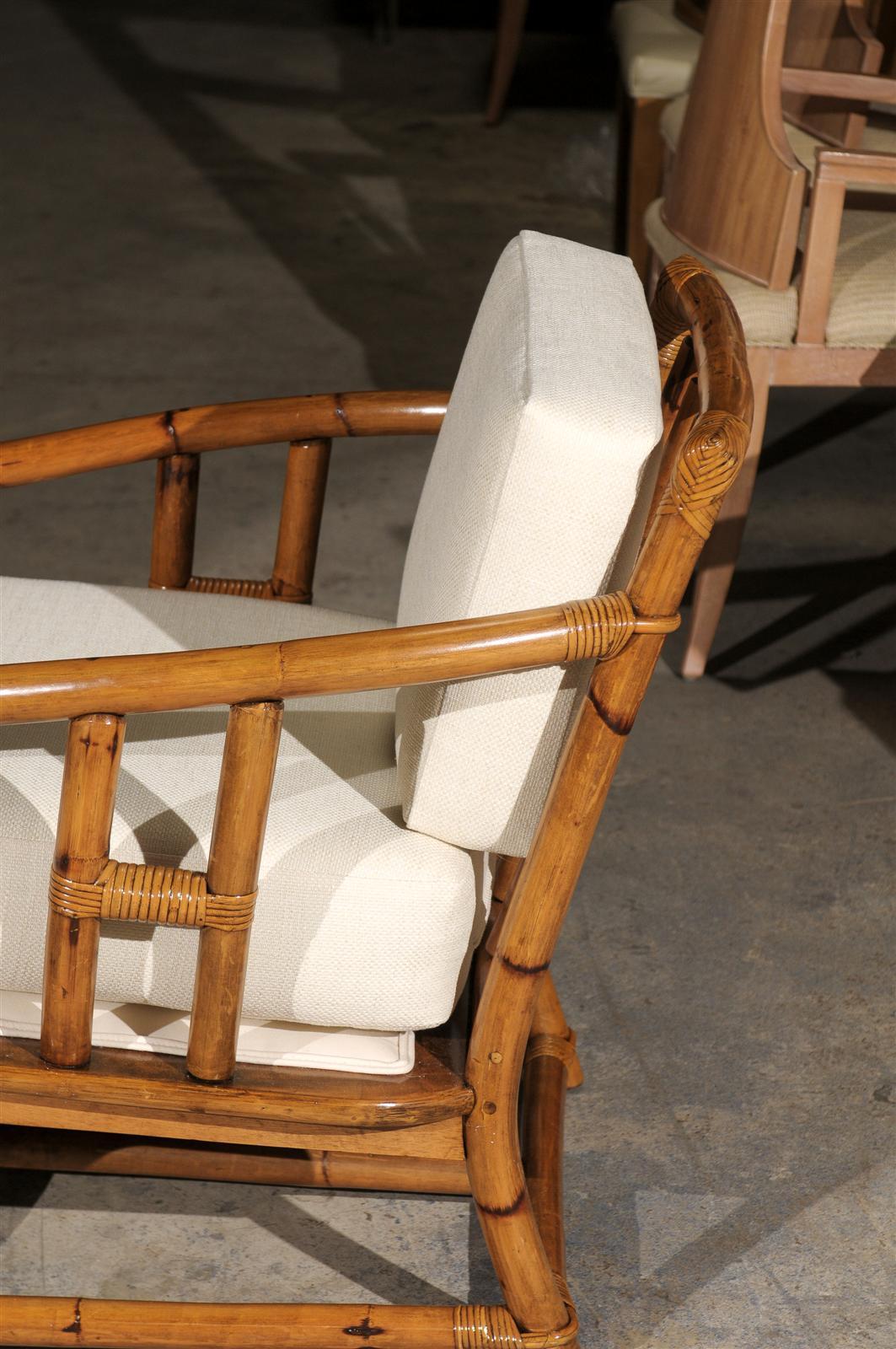 An exceptional pair vintage lounge or club chairs from a low production series by Ficks Reed, circa 1970s. Subtle Asian influence noted at the arms. Stout, expertly crafted rattan and hardwood construction with mortise and tenon joint detail. Fine,