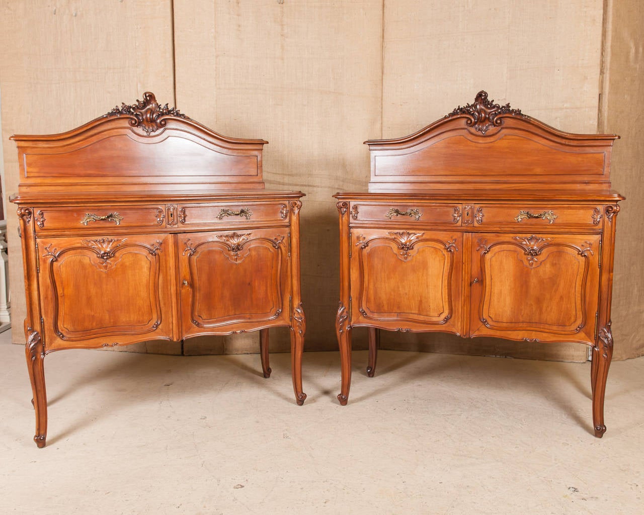 Frédéric Schmit pair of Louis XV style buffets. From La Belle Époque period in France, these beautiful and expertly crafted solid walnut buffets by famous French ebenisterie Schmit are a faithful Rococo Revival, from the elaborately carved flowers