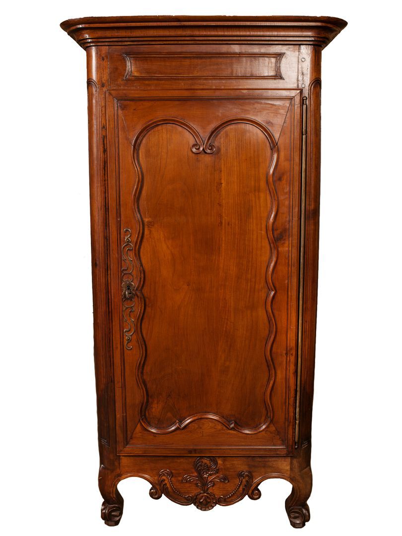 Antique French Country Louis XV bonnetiere. Hand crafted of solid cherrywood. Stepped cornice above medallion paneled door with paneled sides over a carved apron. Rests on short cabriole legs ending in scrolled French toes on pegs. Three interior
