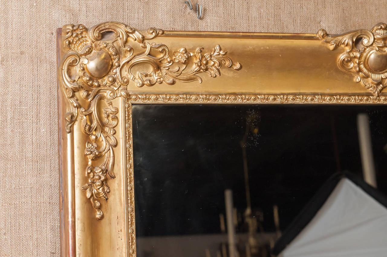 Antique French Louis XIV Baroque mirror. Beautiful hand carving in excellent condition with original gold leaf and original mercury glass. This stately, six foot tall mirror was found in a chateau in Normandy, France.