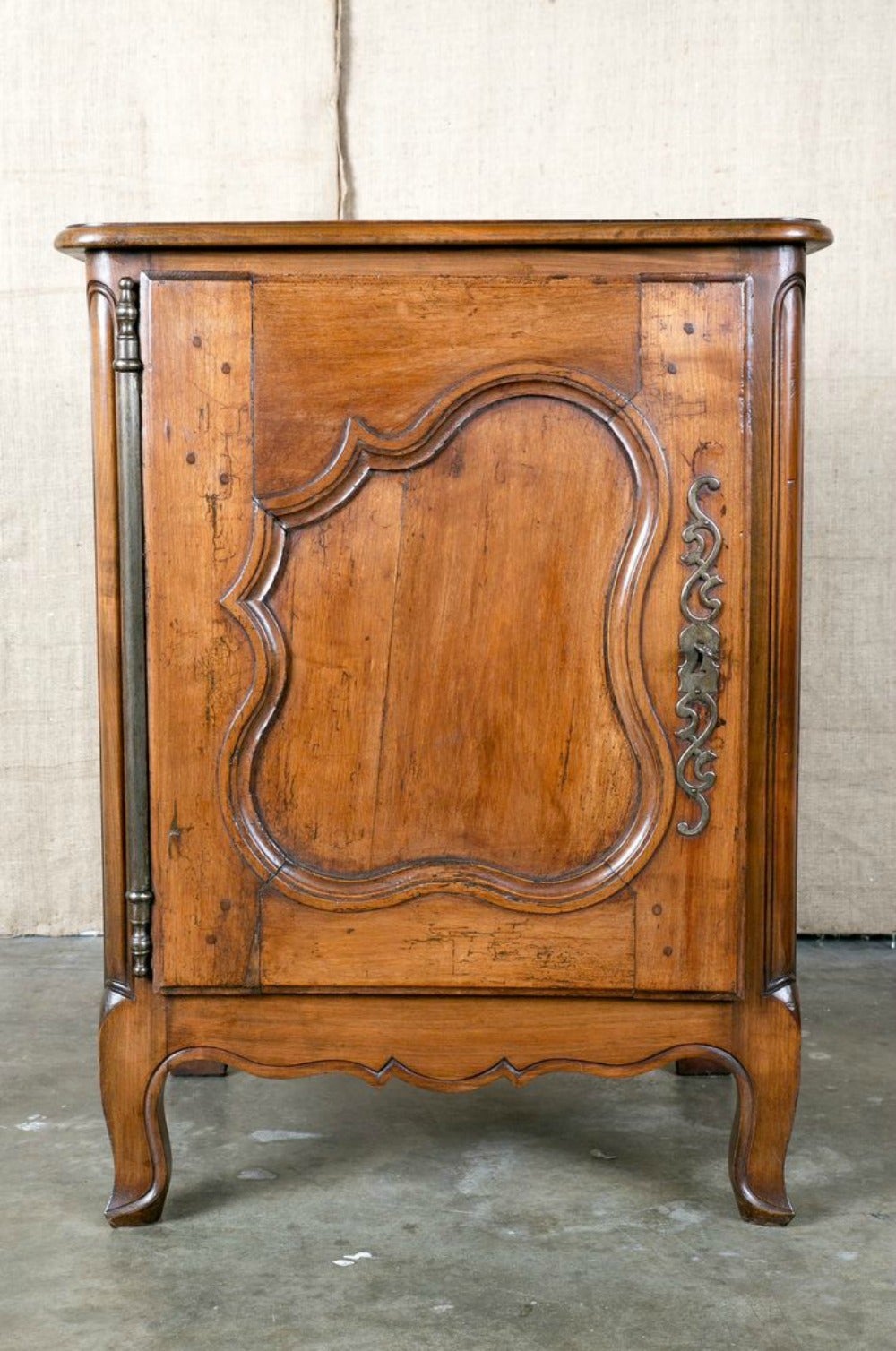 Antique French Country Louis XV style confiturier (jam holder) from Normandie. Handcrafted of cherry wood featuring a single paneled door with unusual full hinge above a carved apron. Raised on short cabriole legs. Single interior shelf.