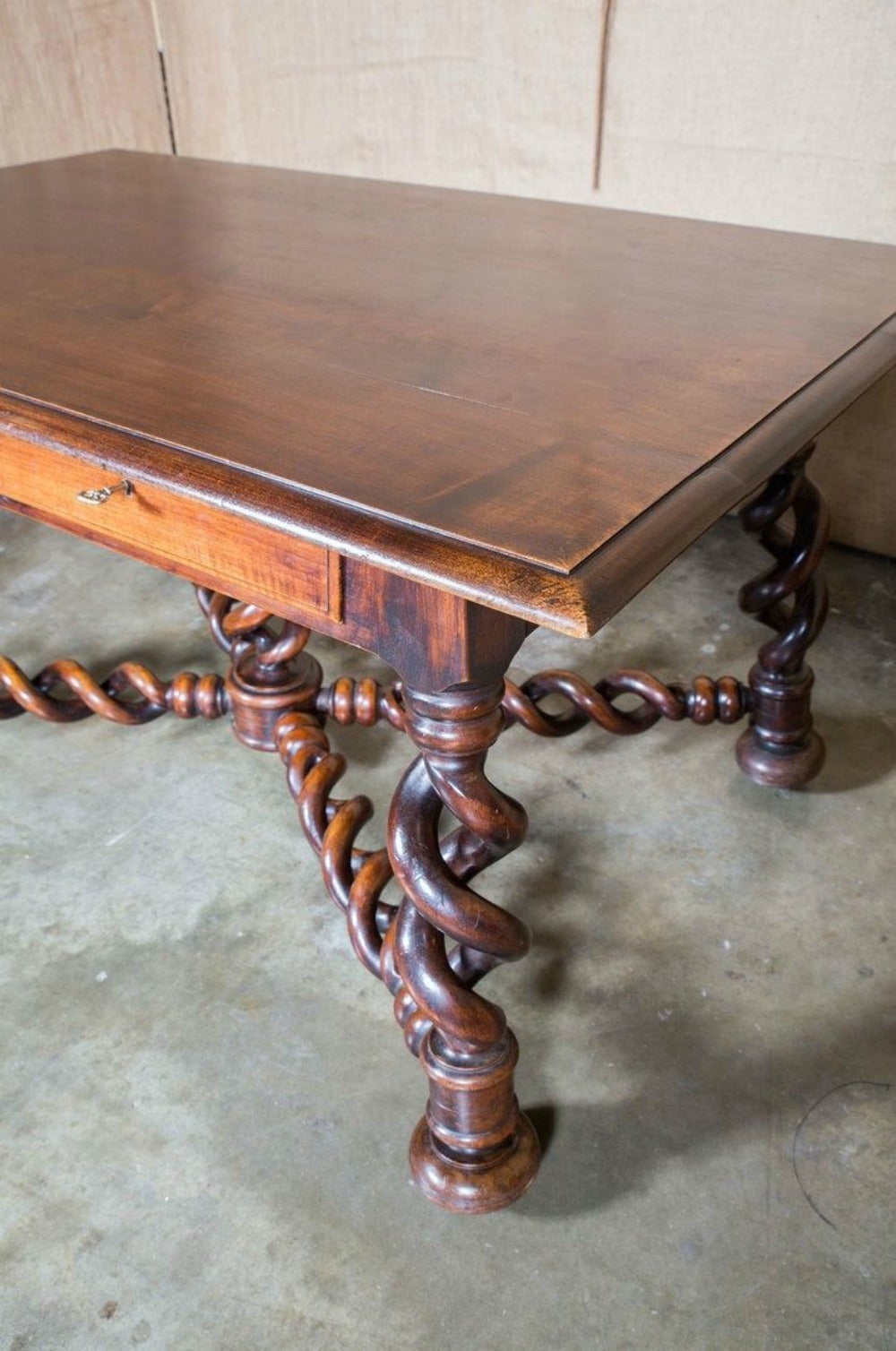 A rare and exquisite Louis XIII style open torsade (barley twist) writing table from the Burgundy region of France. This hand-carved solid walnut desk features a beautiful beveled edge top with a visible yet subtle grain above two drawers resting on