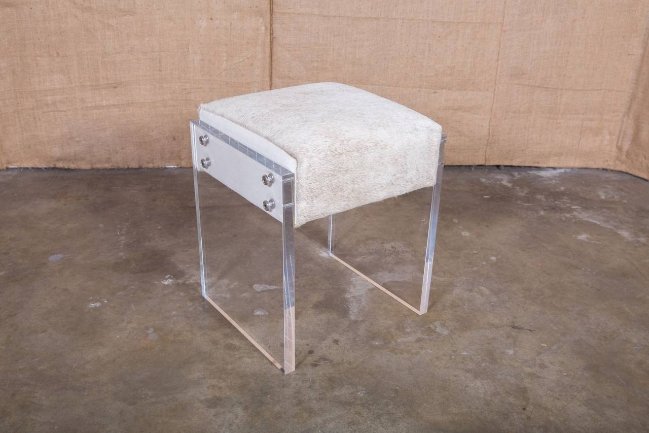 Coco Lucite vanity stool. Use a few to create extra seating or place a pair at the foot of the bed. Add style and a touch of Hollywood Glam to your decor as you apply your makeup. Modern acrylic frame fastens to cowhide seat featuring cream faux