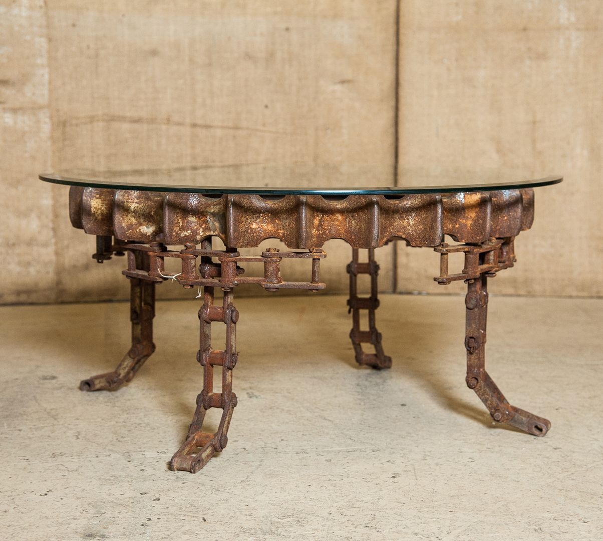 Round, vintage Industrial gear coffee table with beveled glass top. Rusted patina.