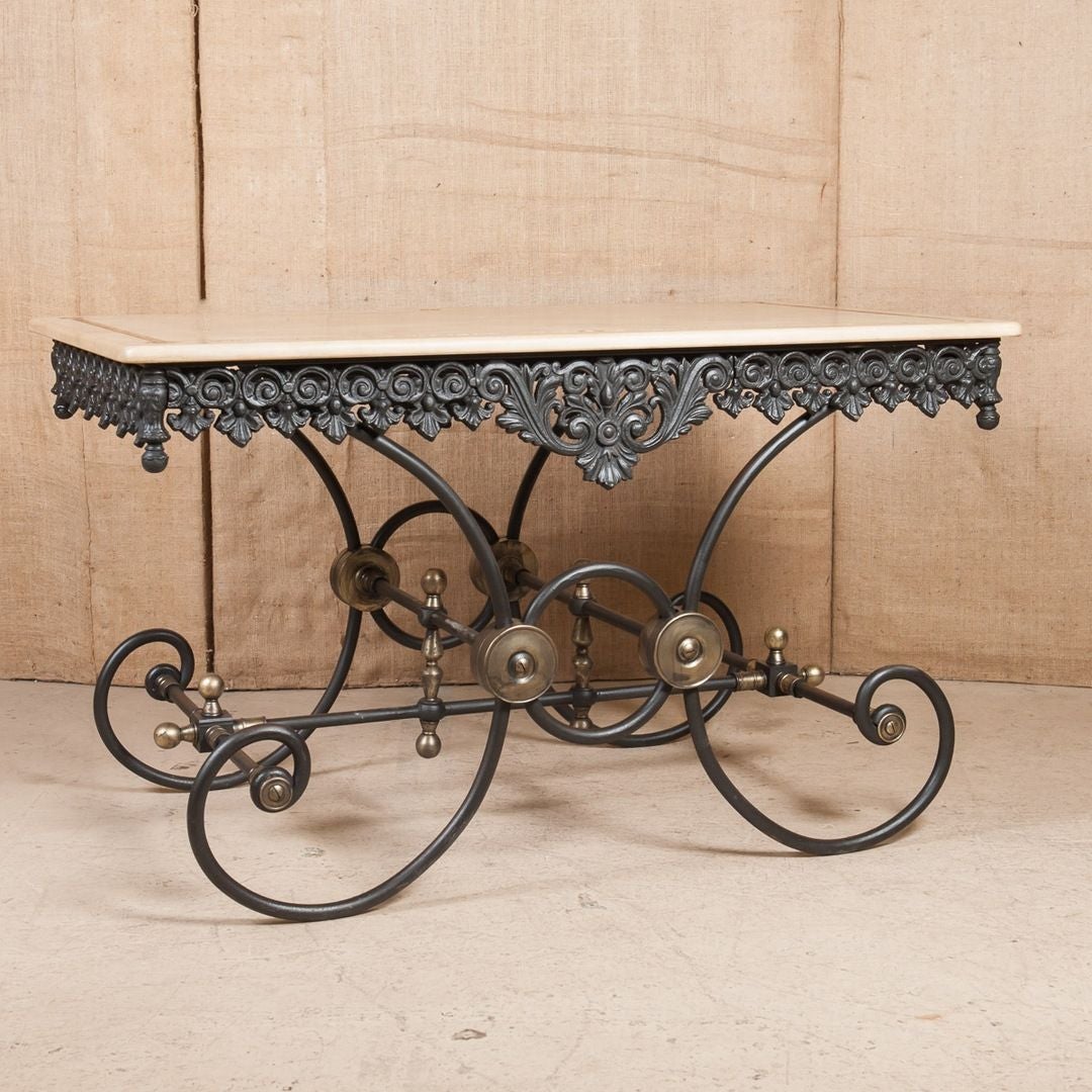 French pastry or butcher's table with a cast and wrought iron base featuring decorative brass elements and a marble top. Some were used to prepare meat, while others were reserved as presentation tables in the shop's window to display the best cuts