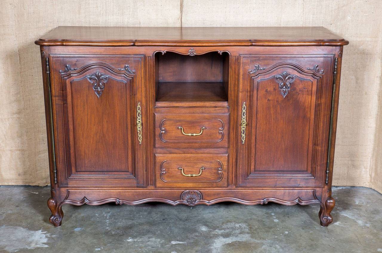 Charming Country French Louis XV style dessert buffet hand crafted of walnut by skilled rural artisans. Center open display section above two drawers flanked by doors having beautifully detailed carving. Scalloped volute apron with rocaille carving