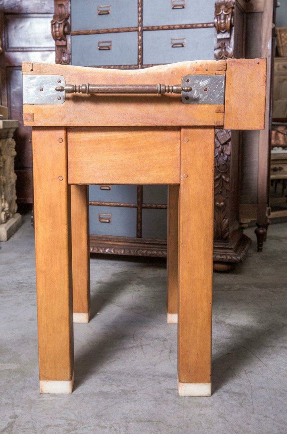 French billot de boucher (butcher block) on four legged stand. The thick top has a distressed patina and slight unevenness from decades of use in a French boucherie. Knife slot along the back of the chopping surface and towel bar mounted on side.