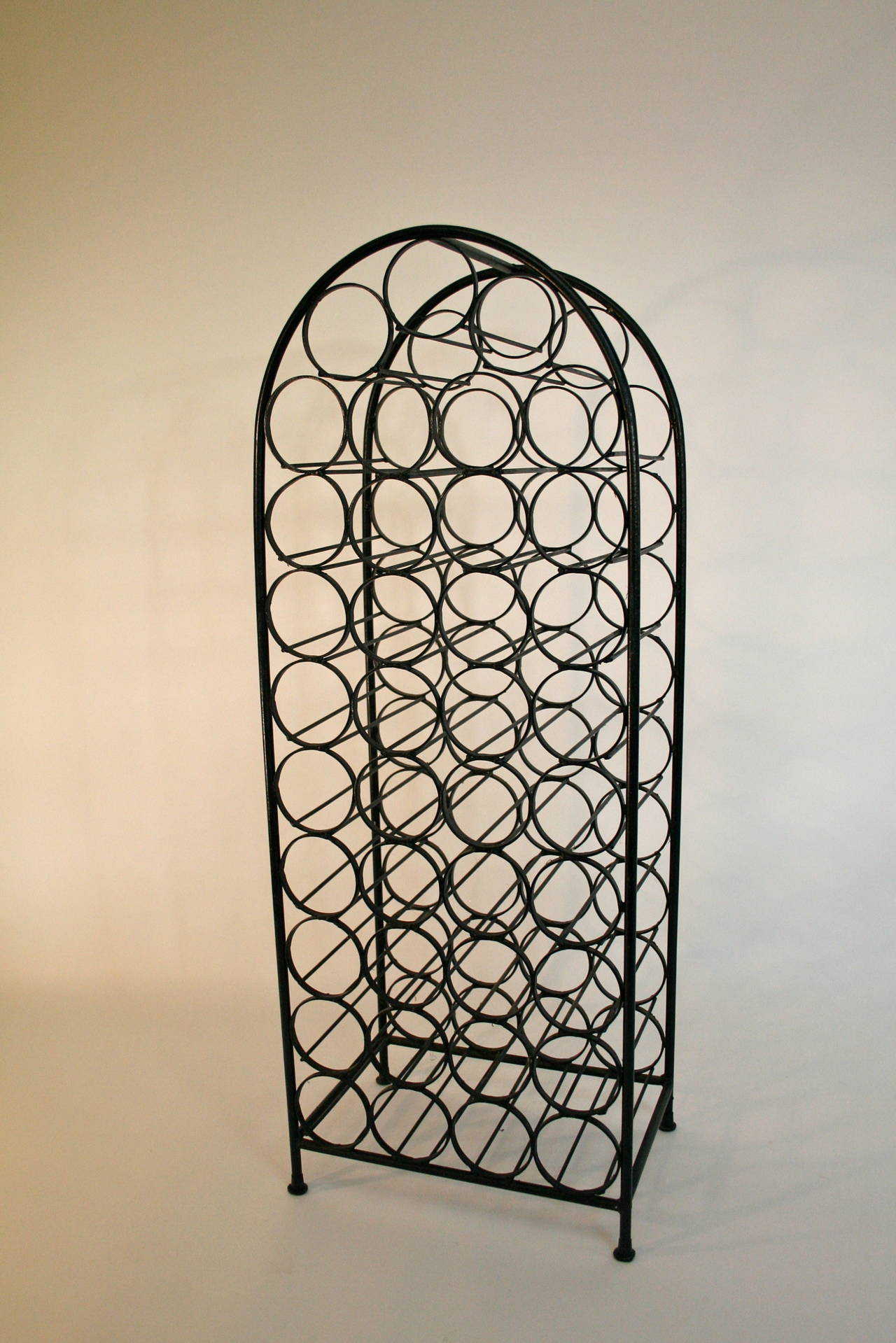 Mid-Century iron wine rack designed by Arthur Umanoff.  Measures 17