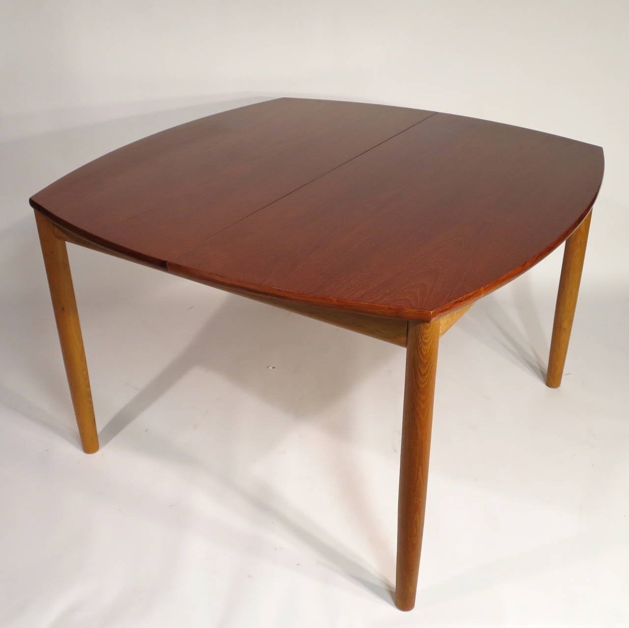 Danish modern draw-leaf dining table by Arne Hovmand Olsen. Teak top with solid oak legs. Made in Denmark, circa 1950s. 
Table was originally paired with six Kurt Ostervig chairs (also available, please message for additional information).