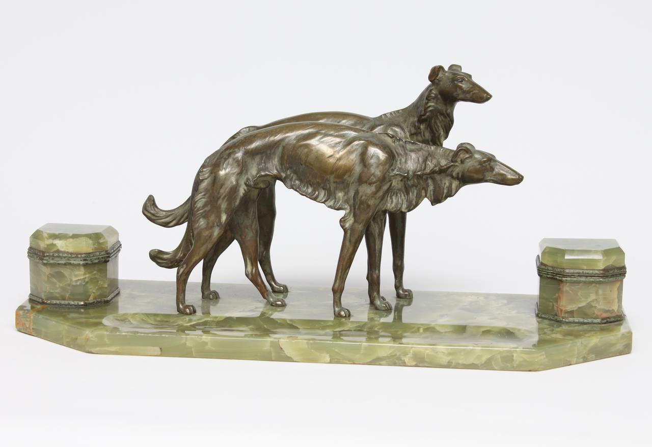 The pair of Borzoi cast in bronze centering the green onyx inkstand with pen tray, with a pair of inkwells.