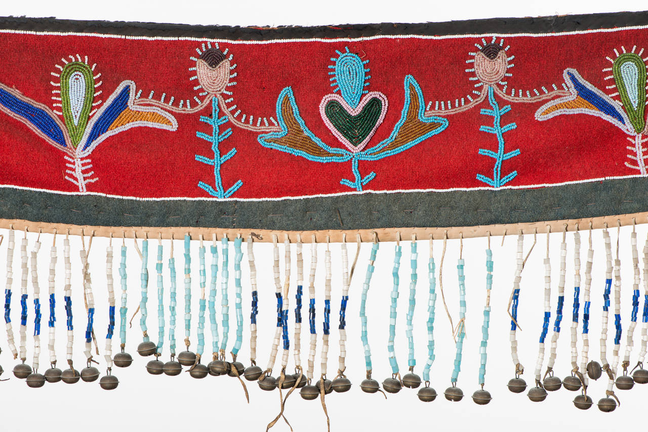 Horse Collar.

Region / Tribe: Northern Plains / Blackfeet (?),

circa 1880s.

Material: Seed beads, stroud cloth, cotton cloths, native tanned hide, hawk bells, wood dowels.

Dimension: L. 50