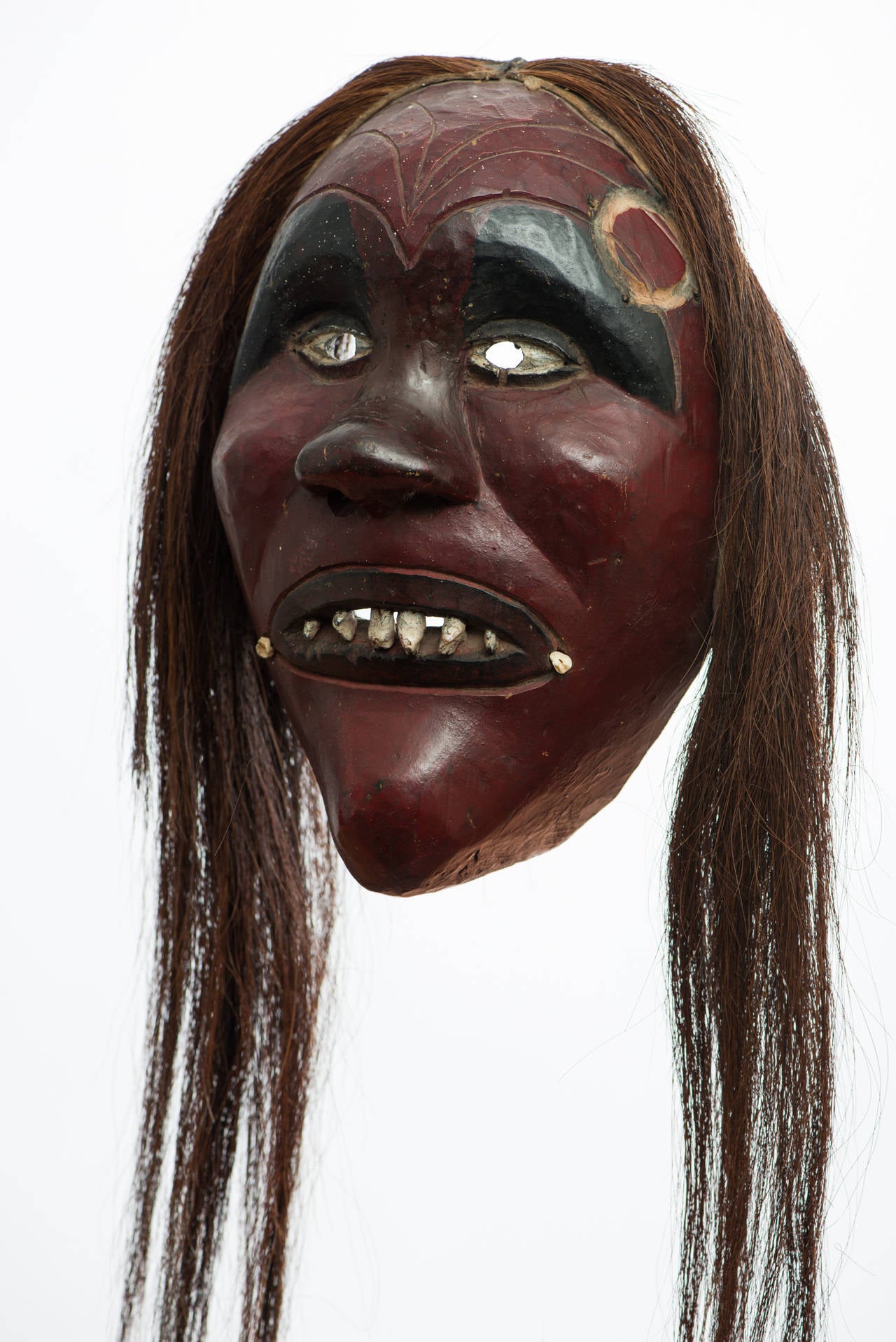 False face society mask.

Region/Tribe: Western New York State/Iroquois,
circa second half of the 19th century.
Material: basswood, horsehair, iron nails, inset teeth, red and black pigment.
Condition: Overall excellent, missing horns, no