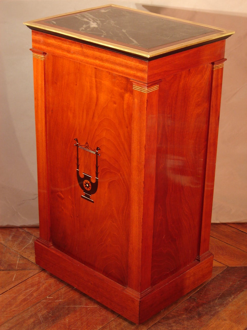 Exceptional somno in mahogany and mahogany veneer from the early 19th  Century Empire period, stamped Marcion (1769-1840), with a wood curtain opening on the top and a door on the bottom, ebony marquetry representing a lyre with an eagle's head on