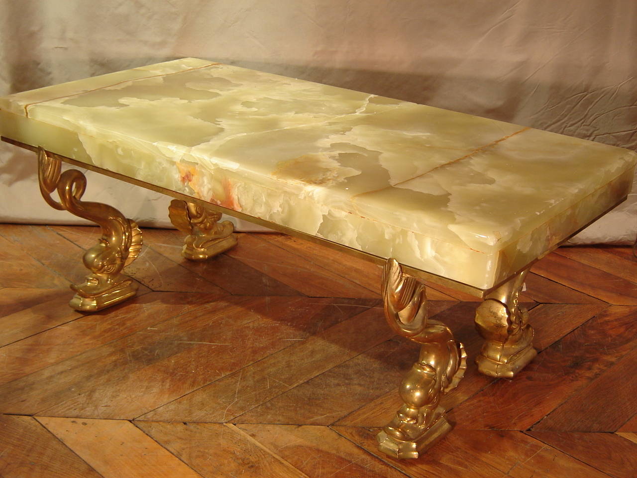Coffee table in bronze and onyx green,very nice coffee table and rare, it consists of a gilded bronze base supported by four dolphins which come to rest in a tray onyx.tout the leg is gilt bronze was gilded, we also note that the tray Onyx has been