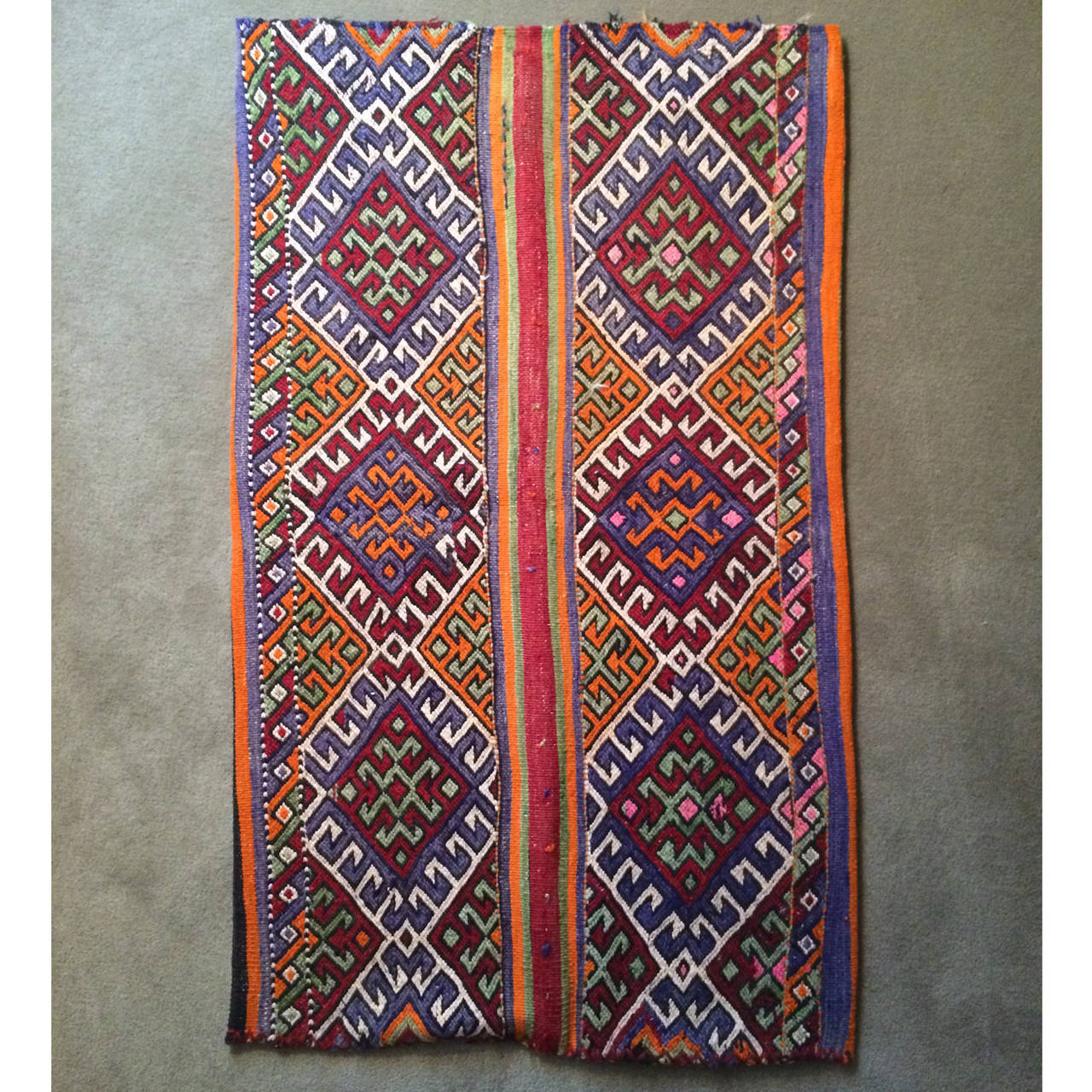 This two sided tribal piece from Southeast Turkey is flat woven with a bright  pattern on the front with traditional motifs, such as the evil eye and ram's horn.  It was originally used to transport and store grains and help preserve other goods.