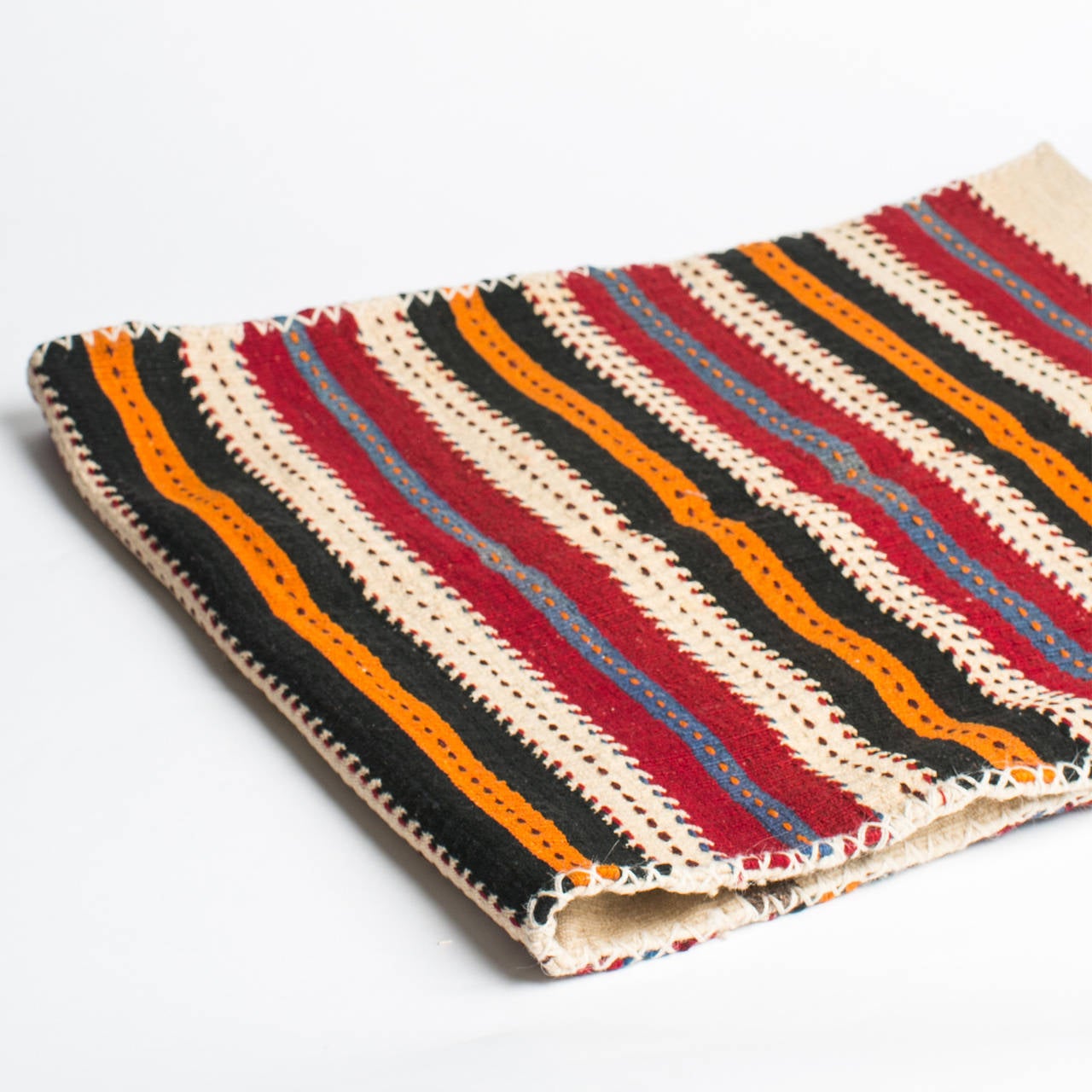 This two-sided tribal piece from Southeastern Turkey is flat woven with a striped on the front, with a more simplified natural color and traditional woven patterns on the back. It was originally used to transport and store grains and help preserve