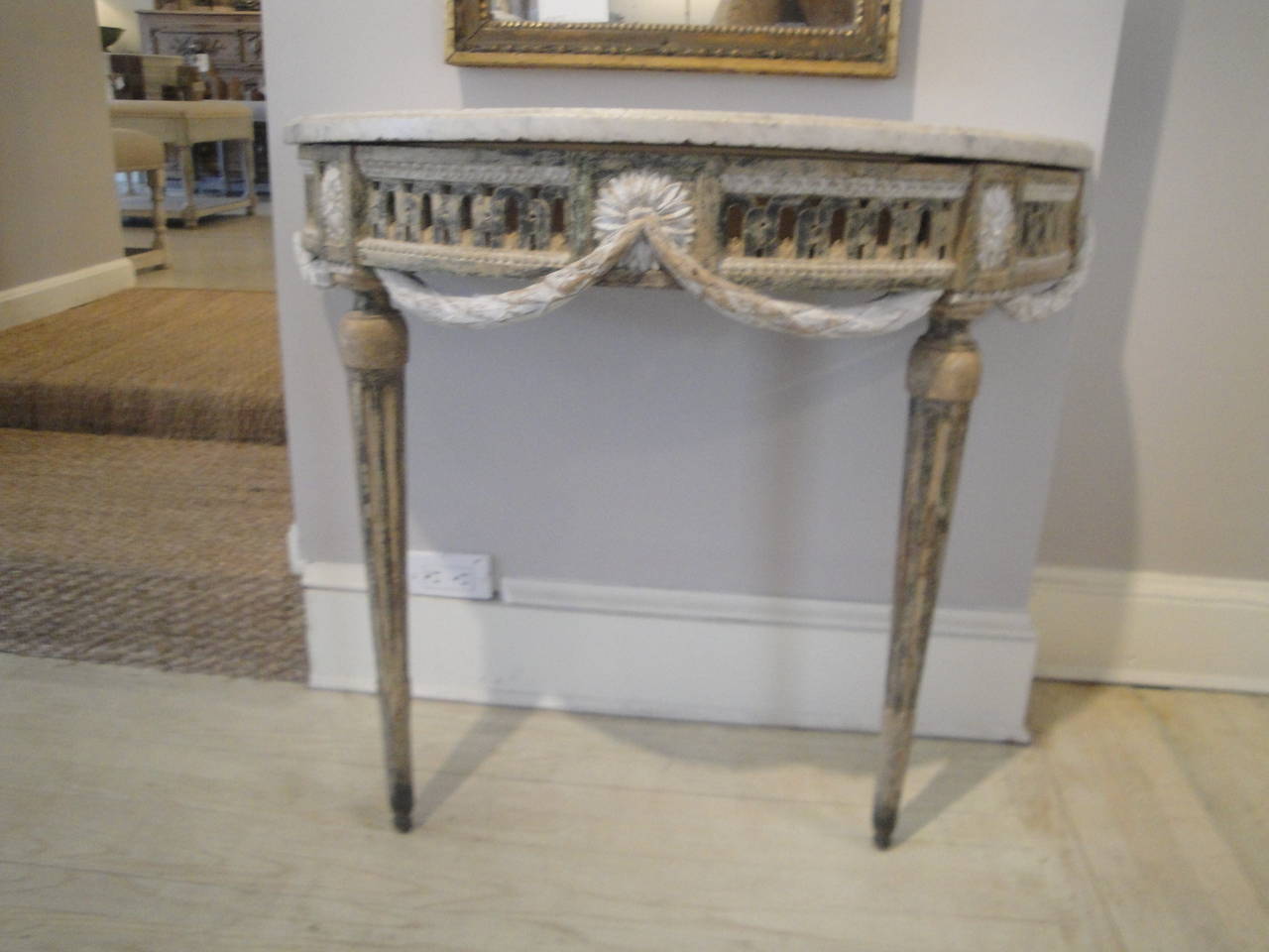 Louis XVI console with deeply carved apron and swags. Original marble top and paint.