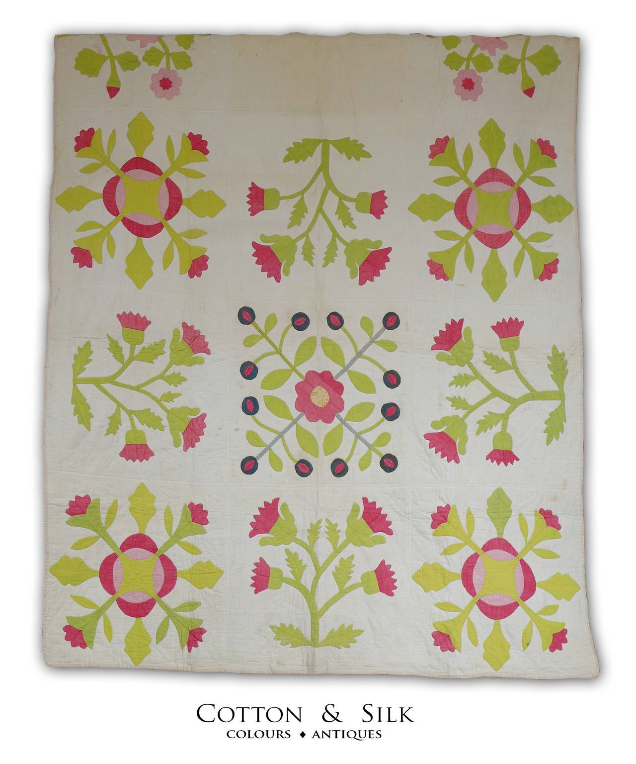 A beautiful applique quilt with red flowers and lime green leaves.