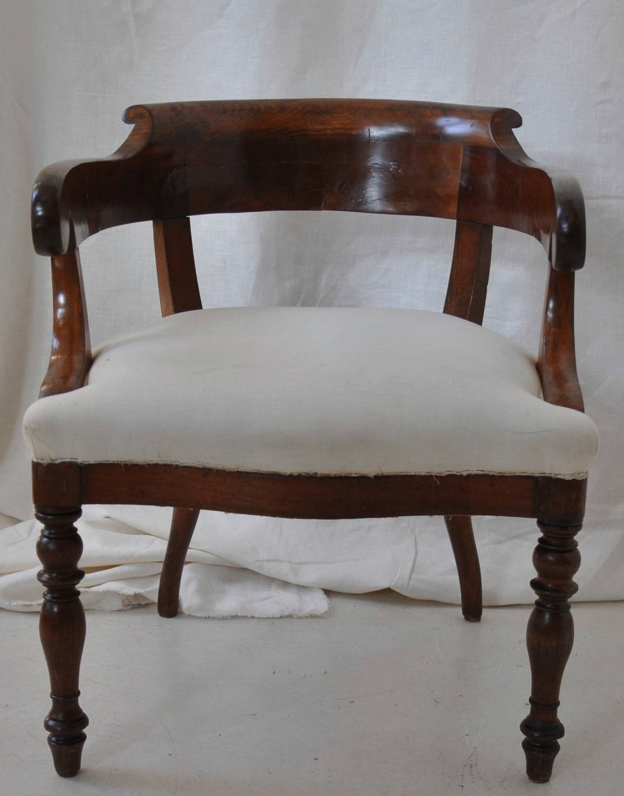 A French 19th century mahogany desk chair with concave back,
inscrolled arms and turned front legs in white muslin.
This chair is professionally restored in the traditional way with copper springs and horsehair through which very comfortable.