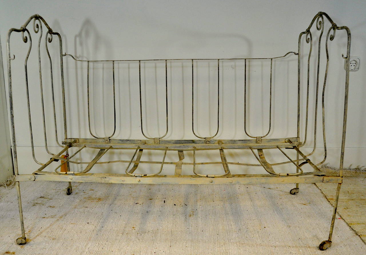 A French 19th century wrought and cast iron folding baby bed. This bed is painted,
Has some scrolling design on the ends and is raised on castors.