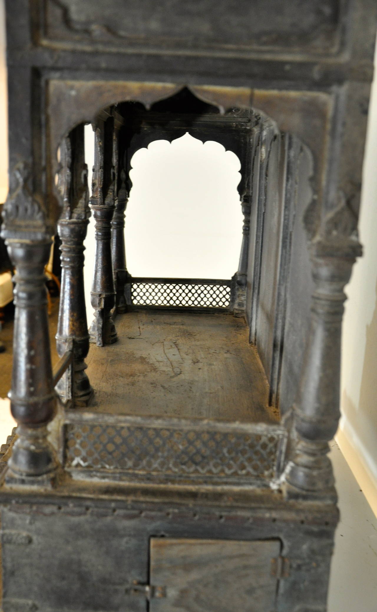 A magnificent Indian shrine with a small door at the left and the right side to protect a hidden place. There are six very finely carved columns to support a roof, who is in itself also a true masterpiece of carved details.