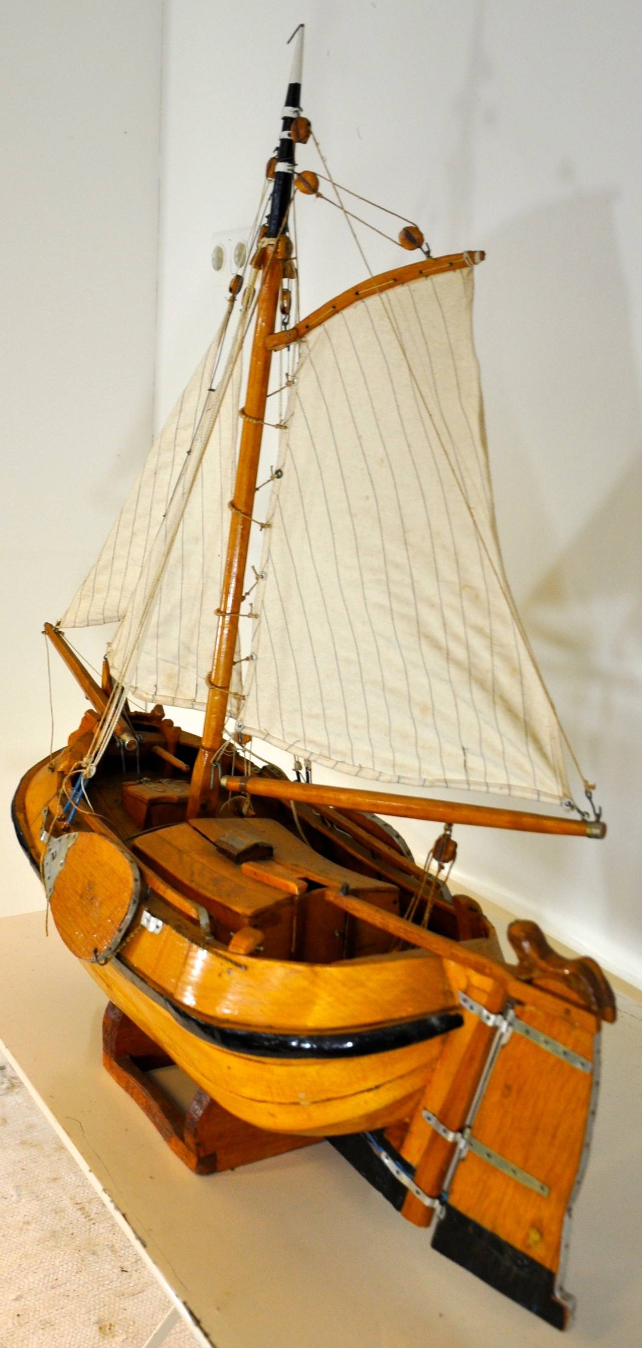 A large wooden model of a Dutch Boeier on a remarkable exact scale with its three cotton sails and pulley's. The display stand is original.