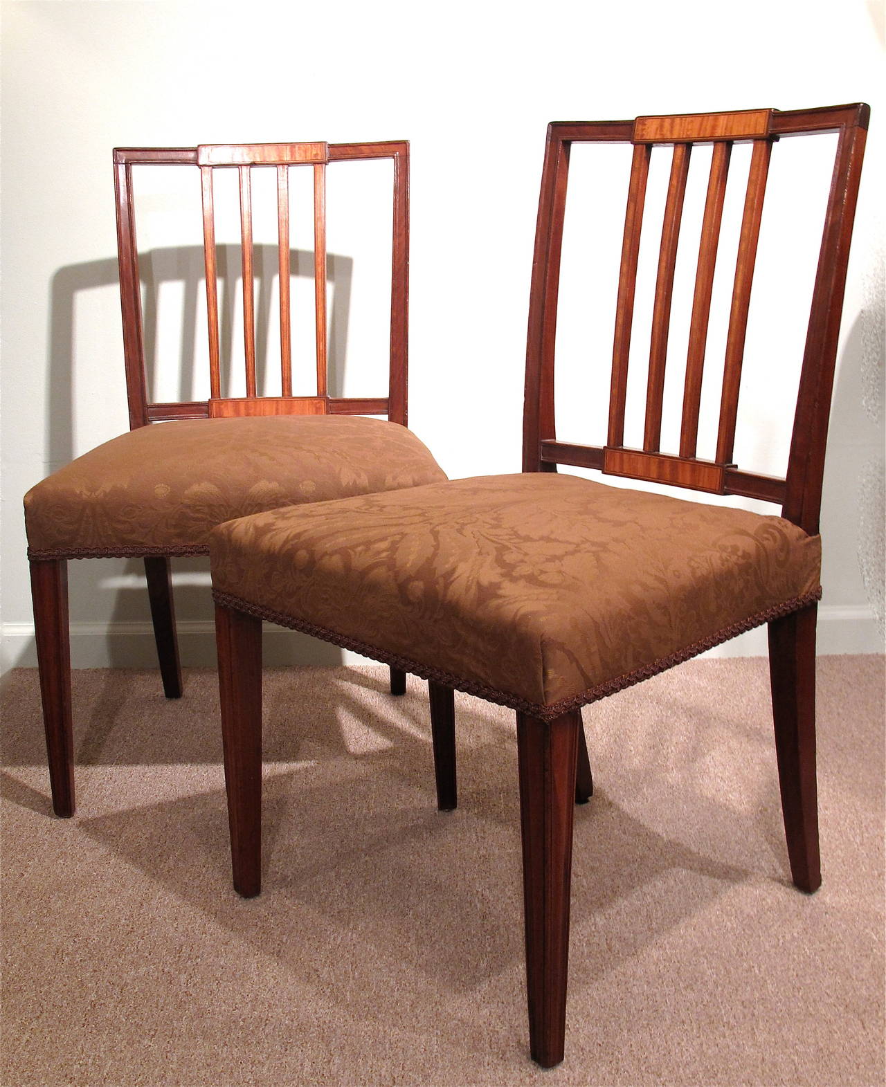 Comprised of 6 period chairs, along with four good early 20th century copies. Composed of mahogany inlaid with satinwood inlay. Squared four-barred backs each have slightly raised satinwood tablet terminals. Each satinwood tablet and splat is