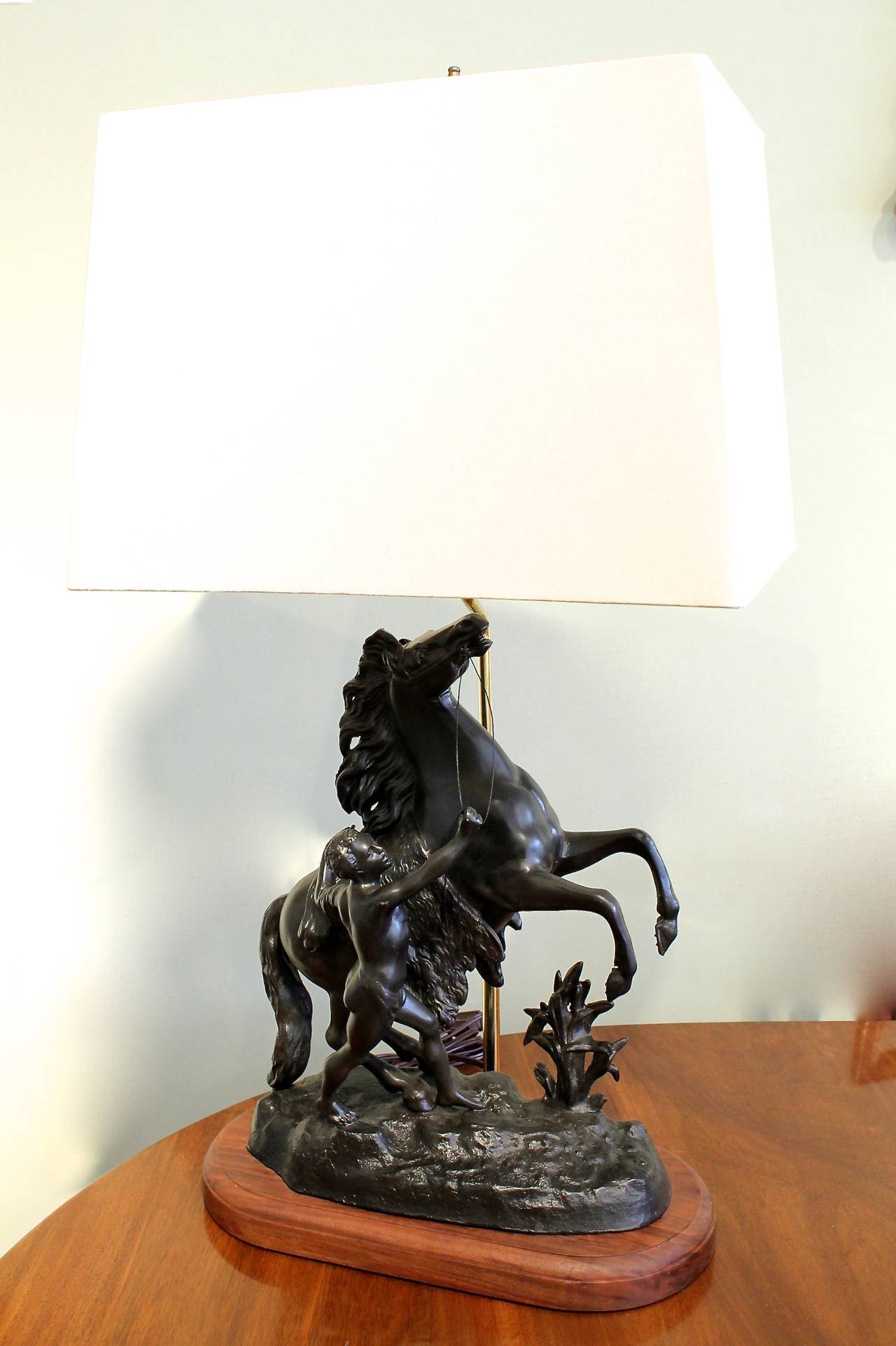 A bronze patinated cast metal (shelter) figural lamp, the horse and young man a copy of one of the “Chevaux de Marly,” marble sculptures by Guillaume Coustou, the originals executed in marble for Louis XIV’s Château de Marly in 1745. This is a ca.