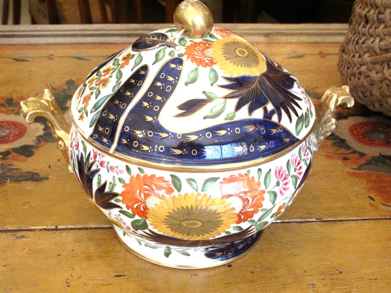 A very fine and rare tureen in the sought after “Thumb and Finger” early English Imari pattern, in very good condition, with marvelous gilded Rococo handles and a gilt apple knob. Fresh pink, orange and yellow flowers enliven the cobalt foliage.
