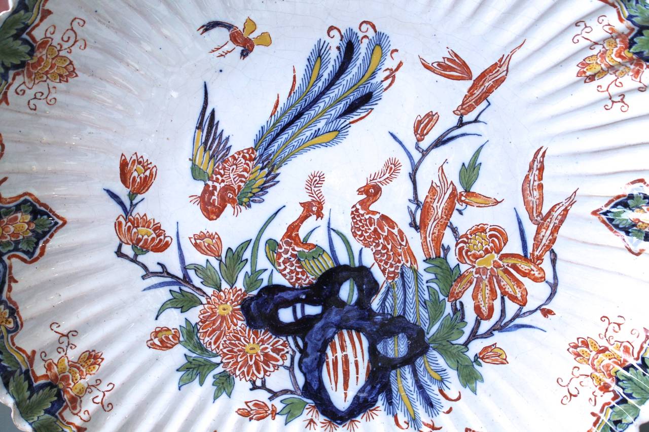 An unusual charger, for its finely fluted form; this type of precise fluting was usually reserved for forms such as large covered jars and vases. With beautiful floral rim decoration surrounding a vignette of peacocks and rockery. Very good