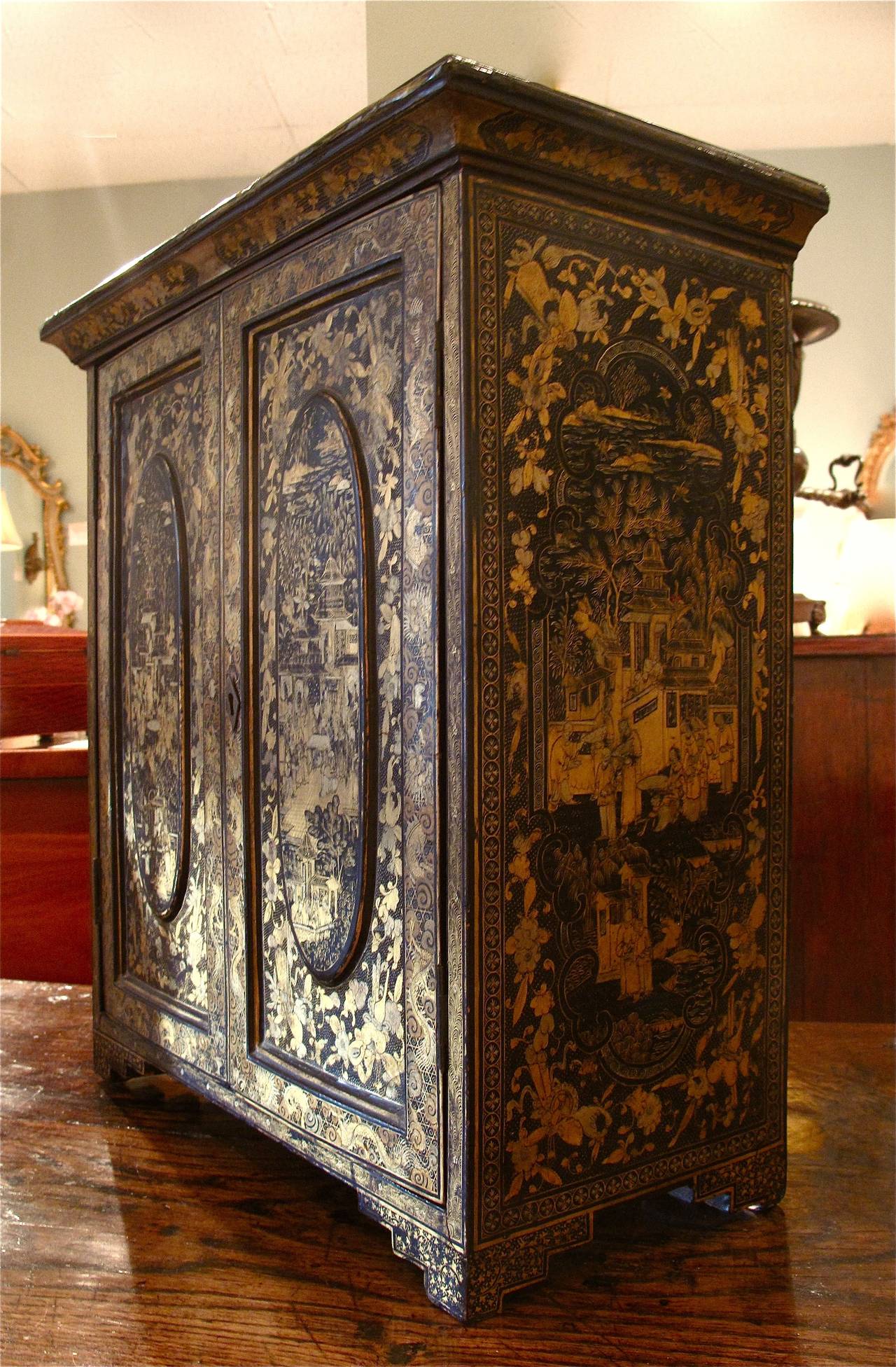 A Chinese export collector’s cabinet dating to the second half of the 19th century, with 5 drawers concealed within exquisitely decorated cabinet doors. Each drawer has a pair of turned ivory pulls.