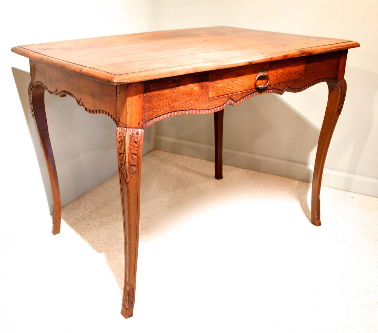 A versatile table of mixed woods: walnut and oak, finished with a carved serpentine skirt on all four sides. Cabriole legs are attractively carved with acanthus at the knee and just above the hoof. Second half of the 19th century. Well executed