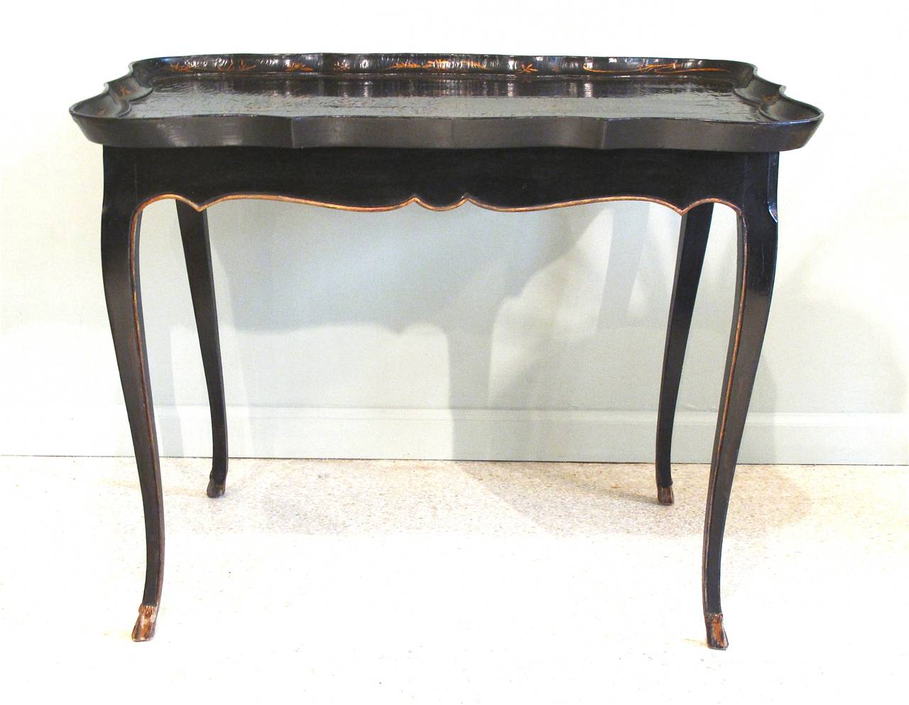A graceful French black painted and parcel gilt occasional table on cabriole legs ending in pied de biche feet dating probably to the second quarter of the 19th century. This table was made to fit the slightly earlier, ca. 1820, Chinese lacquer tray