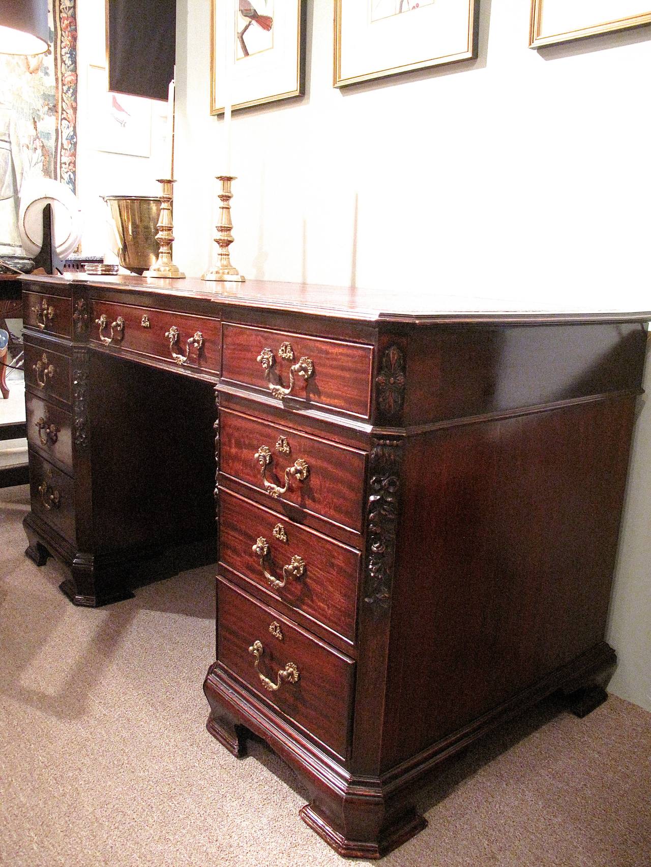 A fine Edwardian era pedestal desk, in the Chippendale manner, with fine gilt brass hardware, good carving on the canted corners and shaped bracket feet supporting each pedestal. Burgundy leather top and working locks.