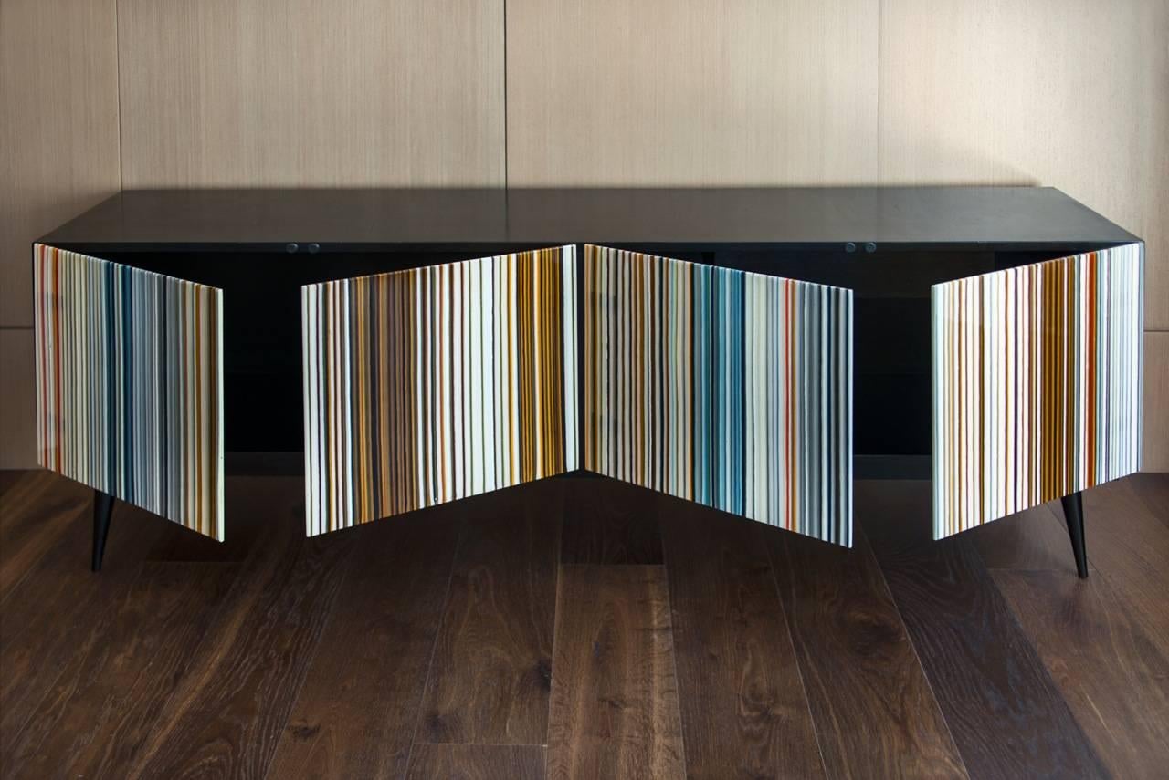 Credenza progettata da Orfeo Quagliata in collaborazione con Taracea Furniture. Un oggetto in vetro fuso creato con l'esclusiva tecnica del codice a barre. Il design retrò di Buff-Heyyy, unito all'eccezionale esperienza del designer nel campo del
