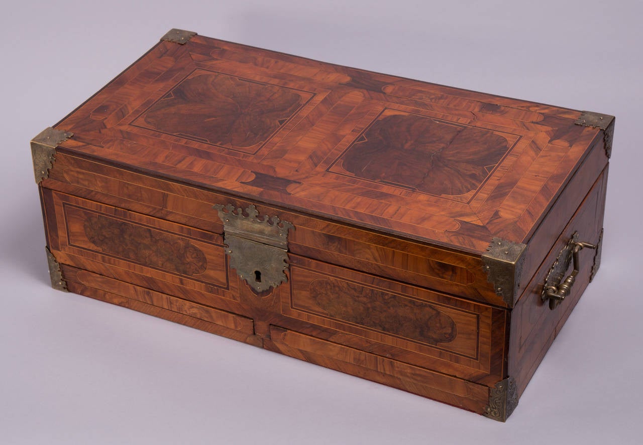 Probably Augsburg, circa 1740.
Nut wood and other native hardwoods and fruitwoods.
Longitudinal rectangular box with hinged lid, on all sides geometric marquetry. Interior with numerous compartments, closed by folding lids, on the front two