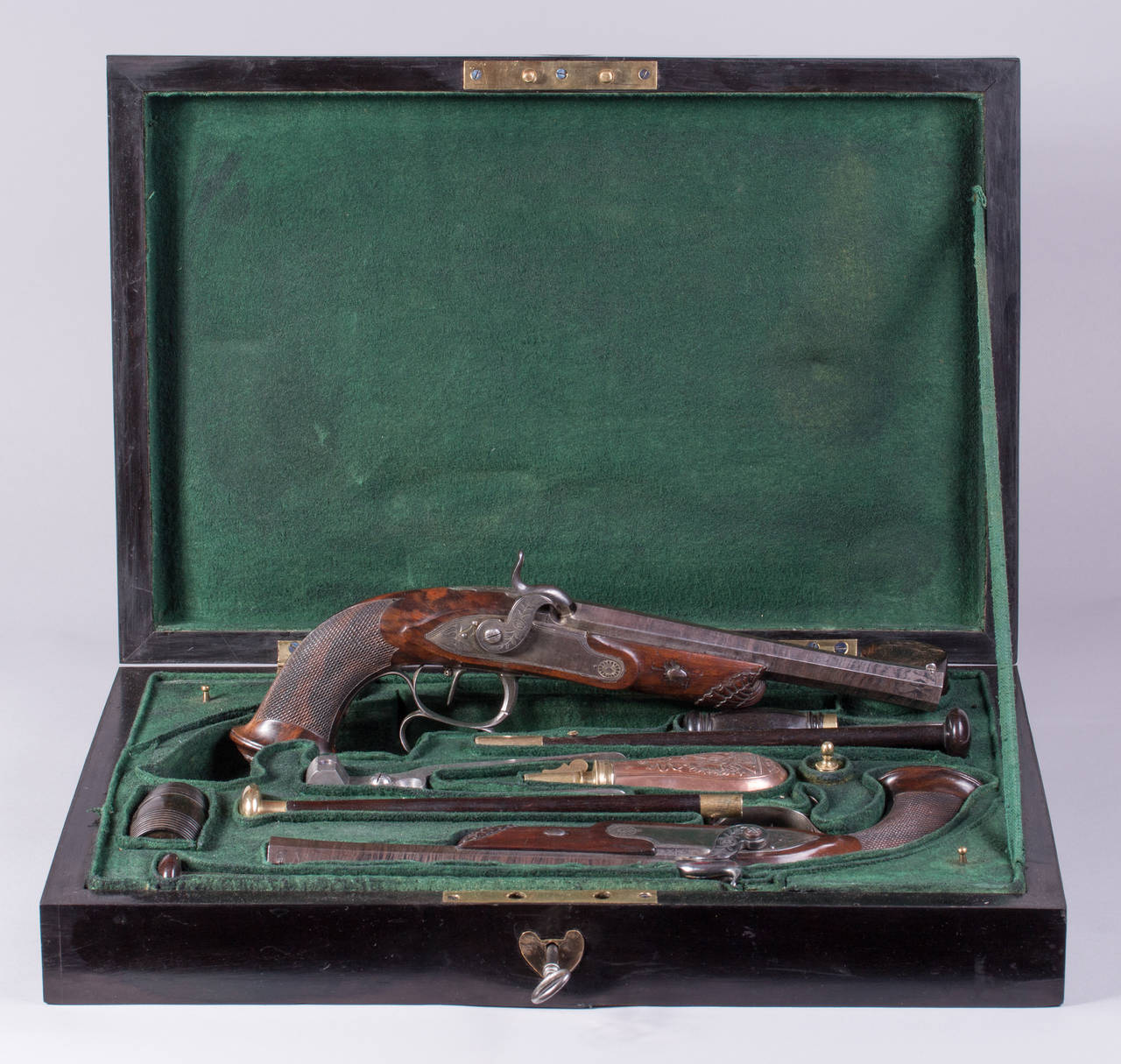 Belgium, circa 1850
Length of pistols: each ca. 36 cm, 14 mm caliber
Measure of case: 48 x 33 x 10 cm
Smooth barrels, engraved iron fittings, walnut wood shafts with carvings, ebonized wooden box with accessories.