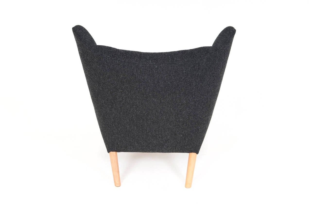Hans J. Wegner papa bear chair and ottoman, model AP19 and AP29.

Oak nails and legs. (Ottoman in oak) new dark grey fabric upholstery, executed as original.

Designed 1951.
Manufacturer: AP Stolen.