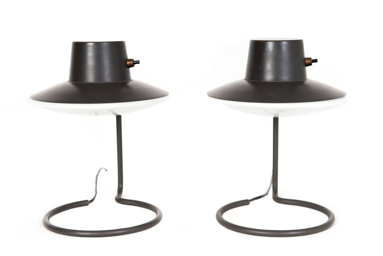 Arne Jacobsen. Saint Catherine table lamps.

Grey-varnished metal stem and shade. Brass contact. Glass shade.

Designed for Saint Catherine's College, Oxford, circa 1962. 

Produced by Louis Poulsen.

Measures: W: 22 cm. H: 29.50 cm. D: 24