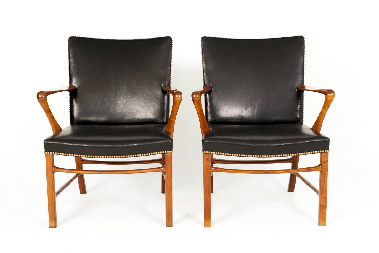 A pair of armchairs in nutwood and Niger leather, fitted with brass nails.