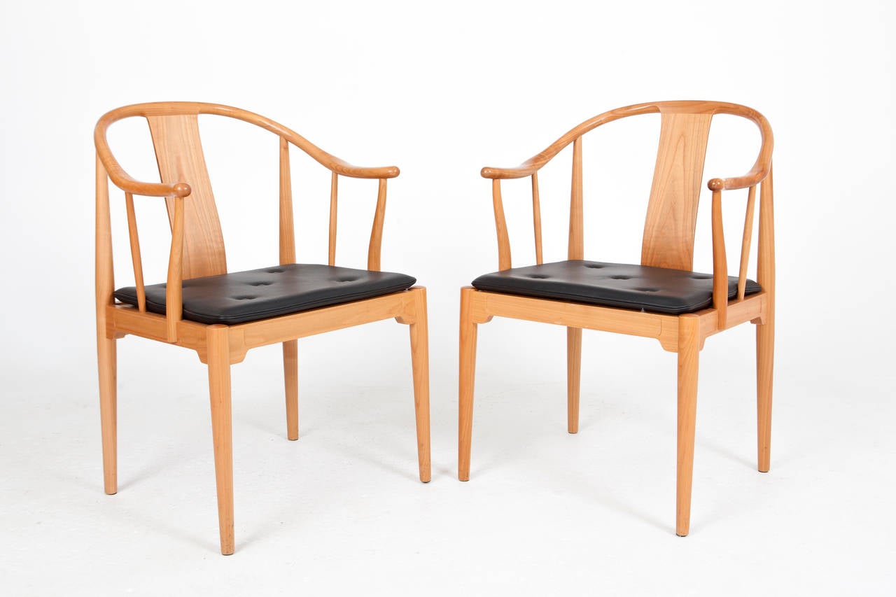 Hans J. Wegner, China chair.

A pair of cherrywood armchairs. Loose seat cushion upholstered with black leather, fitted with buttons. 

Designed 1944. 
Manufactured and marked by Fritz Hansen.
