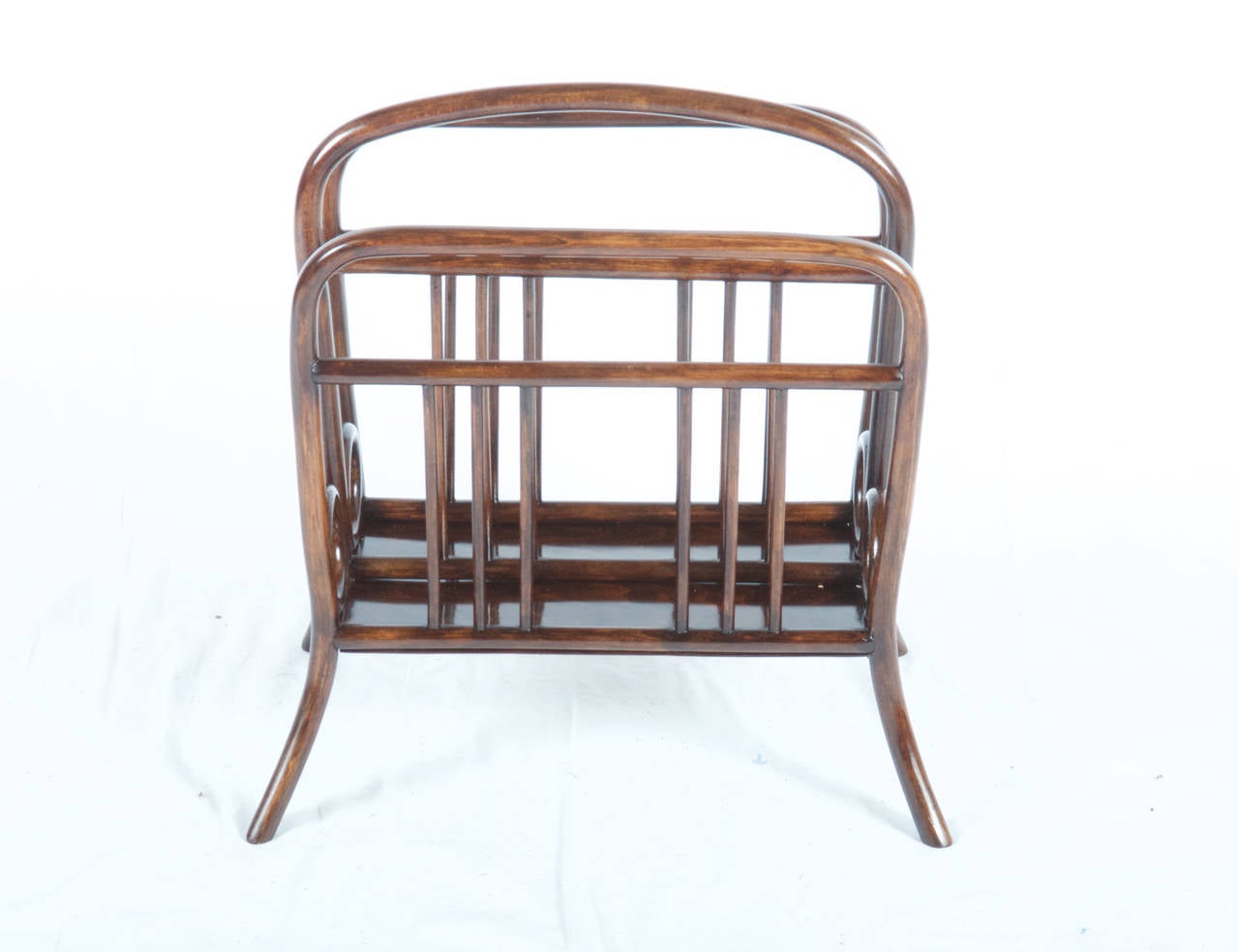 Open, four-footed stand, center vertically divided into two parts, subdivision highly performed as loop handle, side panels with dainty rung of round rods. 

Dimentiones: H. 54 cm; 47.5 x 27 cm. Model no. 11834th 
Beech, bentwood of squared