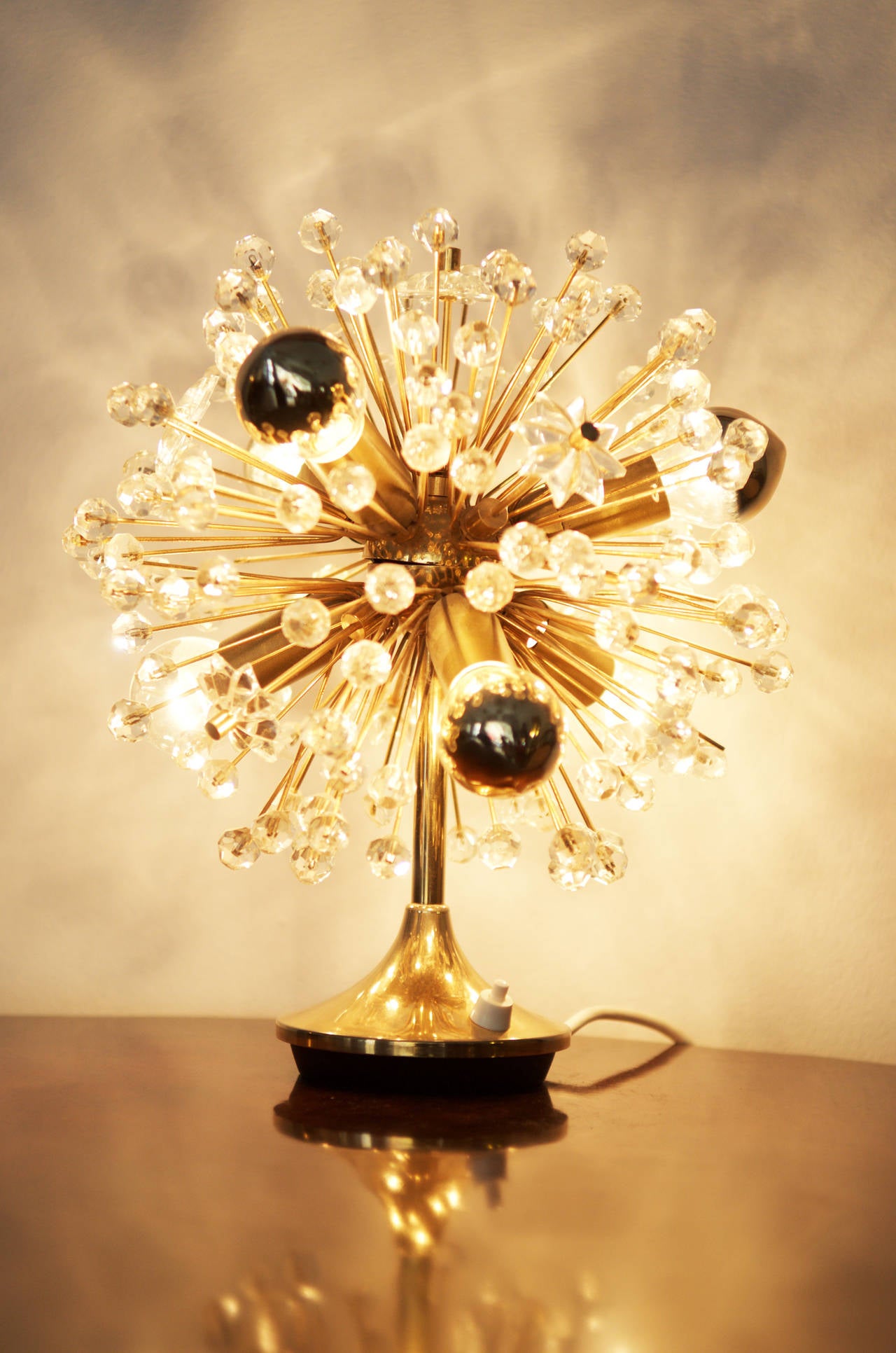 Blowball table lamp from about 1960.
Gold-plated brass, glass flowers and glass stones.