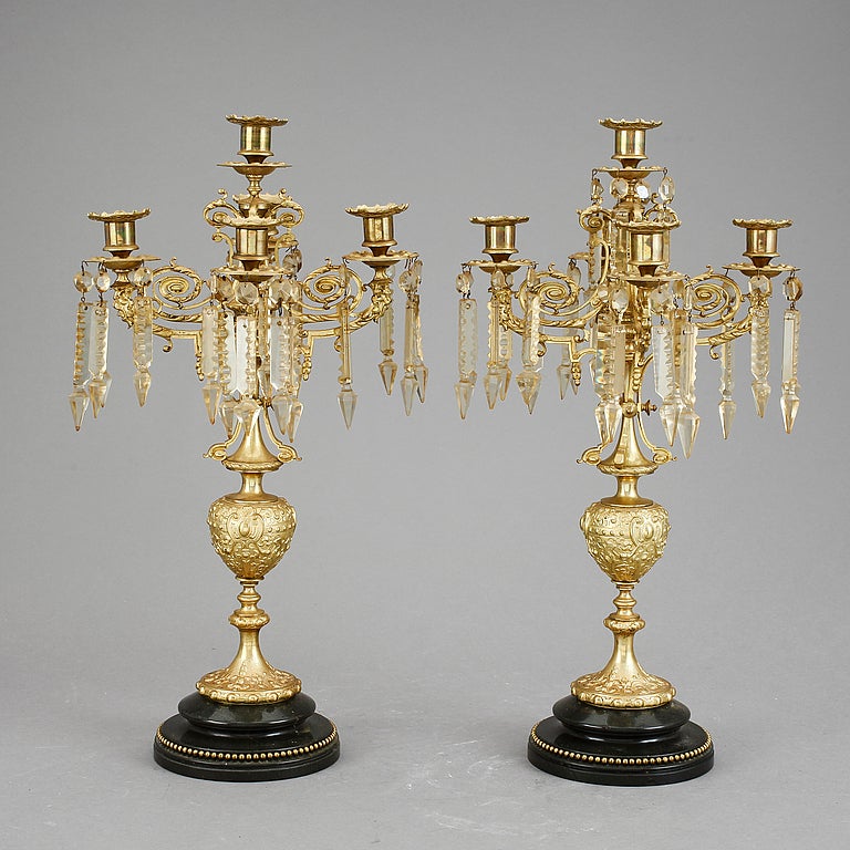 Period of Oscar II (1872-1907) was indicative of e new found interest in the antique and eastern styles. The style is known for its mixes of Gothic, Renaissance, Baroque and eastern styles. Brass on stone base with a couple of crystal drops missing.
