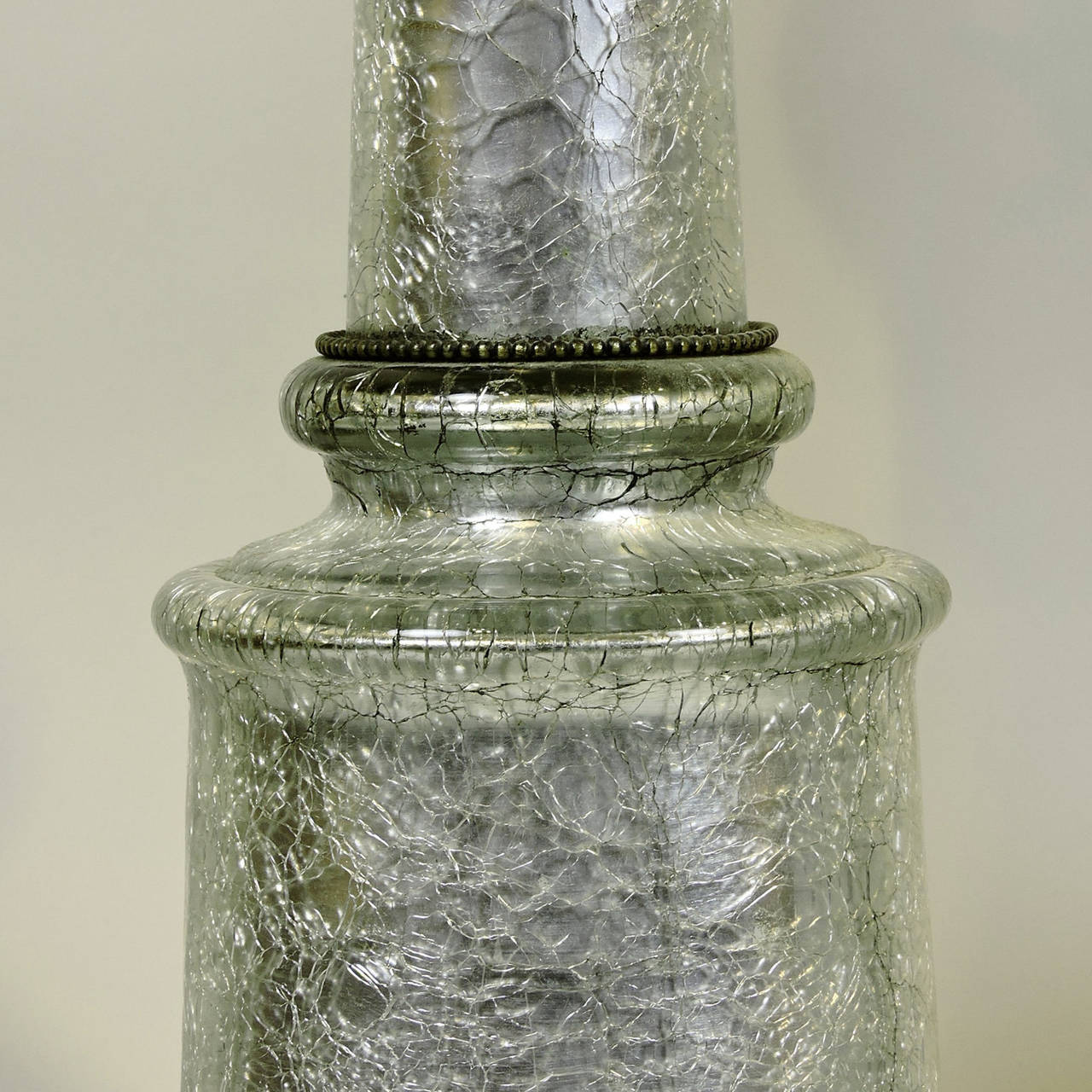 Pair of dramatic silver crackle glass column-form table lamps, with beaded bronze accents and base, 20th century. Similar to gold examples made by Paul Hansen in the 1950s for Hollywood Regency.
Measure: Glass 23 inches, diameter 7 1/2 inches.