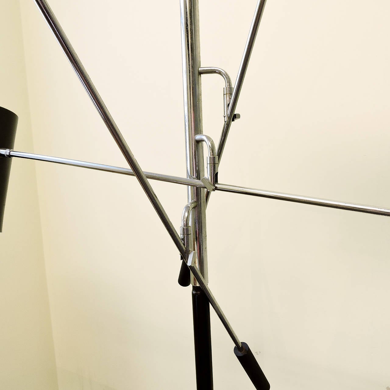 A fine Mid-Century Modern three-light floor lamp. Standing patinated metal post features three chrome adjusting poles with black enamel painted spotlight shades. Possibly by Arredoluce. Dimensions: Height 70 inches, base 12 inches diameter,