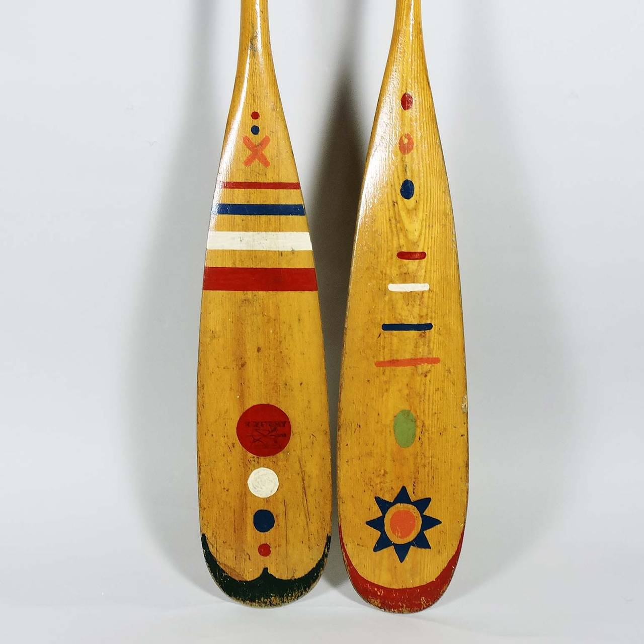 Two vintage hand-painted canoe paddles, one with Native American motif, other bears inscription 
