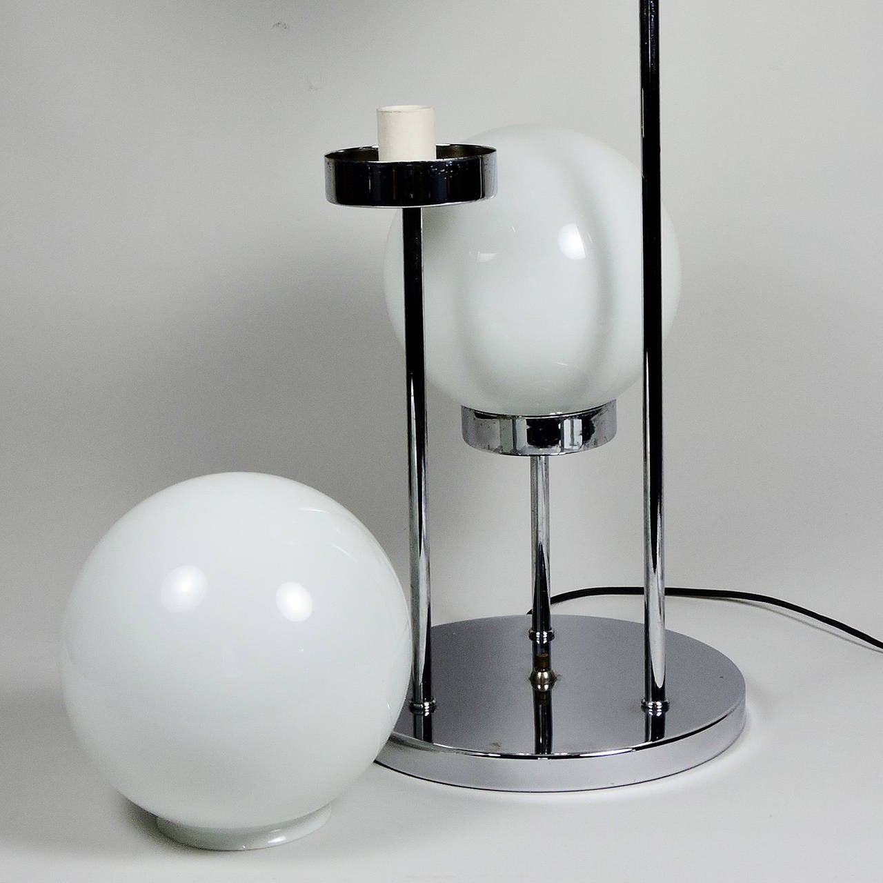 Mid-Century Modern Italian three-globe table lamp, possibly by Reggiani. Measures: Height 29 inches, base 10 1/4 inches, globe diameter 7 inches.